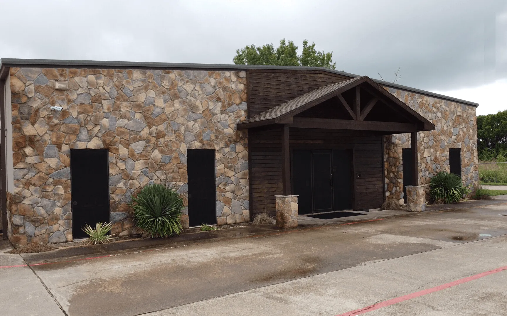 SBA Loan Asset - front entrance, stone wall, parking lot
