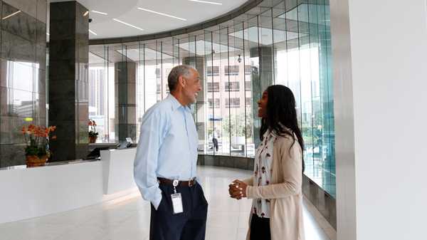 African American man and woman talking in lobby of office building