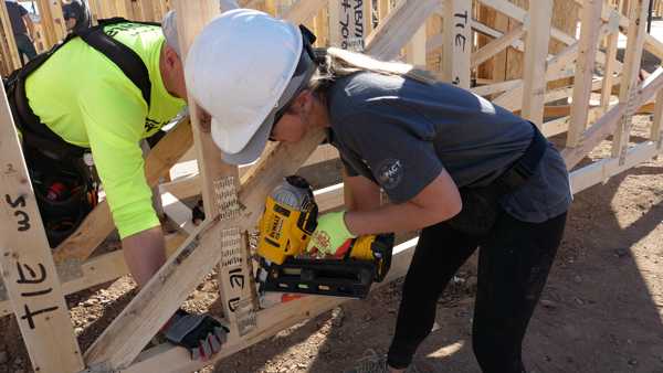 CIM employee using nail gun on trusses at Habitat for Humanity and CIMpact volunteer event